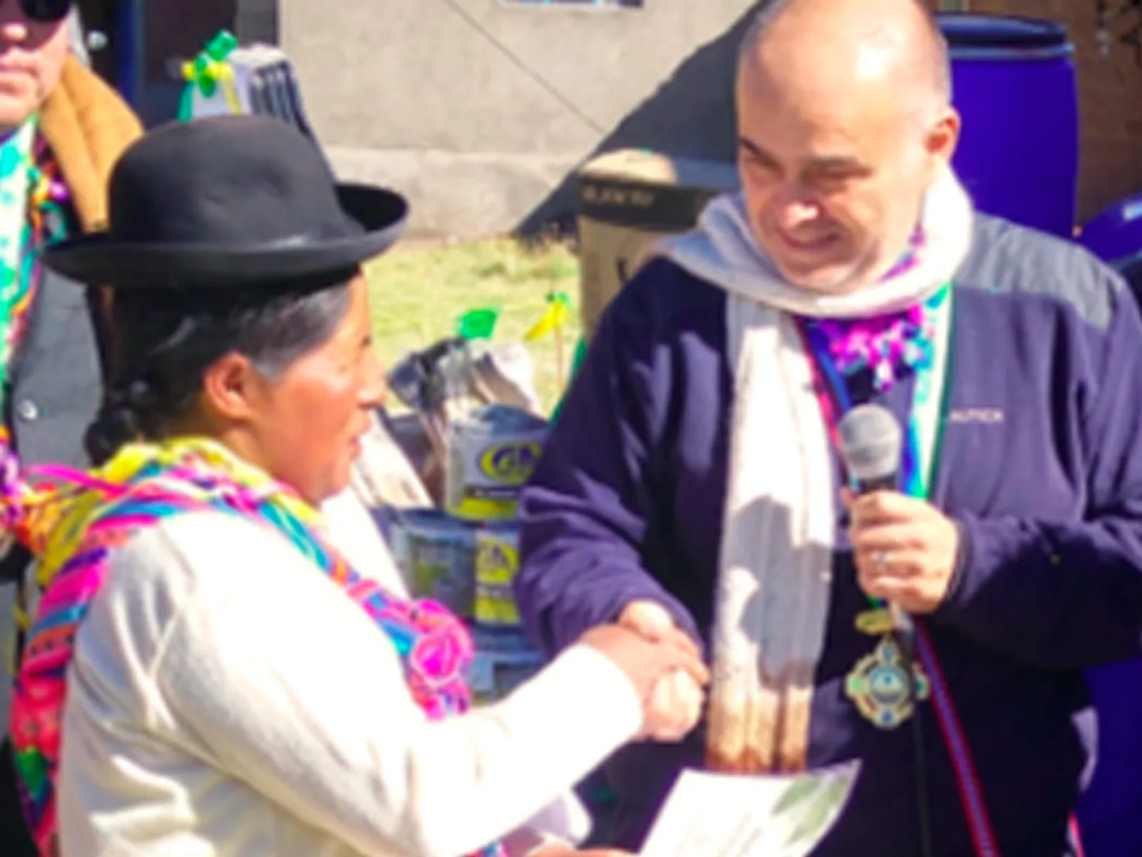 A RESCA representative handing a conservation agreement to a farmer